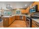 Bright eat-in kitchen with stainless appliances, light wood cabinets, and window overlooking backyard at 9869 Burberry Way, Highlands Ranch, CO 80129