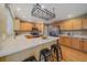 Well-lit kitchen with stainless appliances, light wood cabinets, and center island with breakfast bar at 9869 Burberry Way, Highlands Ranch, CO 80129