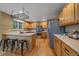 Well-lit kitchen with stainless steel appliances, a breakfast bar, and hardwood floors at 9869 Burberry Way, Highlands Ranch, CO 80129