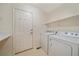 Functional laundry room with washer, dryer, shelving, and access door at 9869 Burberry Way, Highlands Ranch, CO 80129