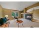 Cozy living room with vaulted ceiling, fireplace, and large window offering backyard views at 9869 Burberry Way, Highlands Ranch, CO 80129