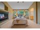 Serene main bedroom with ensuite access, fireplace, and large windows offering backyard views at 9869 Burberry Way, Highlands Ranch, CO 80129