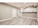 Spacious basement area with wood-look flooring, white cabinets, and a door to the unfinished portion at 14952 Vienna Cir, Parker, CO 80134