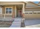 Welcoming front entrance with stone accents, covered porch, and a convenient two-car garage at 14952 Vienna Cir, Parker, CO 80134