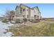 Two-story townhome with a partially snow-covered lawn at 15800 E 121St Ave # 3J, Brighton, CO 80603
