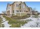 Tan and green two story townhome with snow covered landscaping at 15800 E 121St Ave # 3J, Brighton, CO 80603