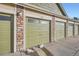 Attached garage with green doors and additional storage at 15800 E 121St Ave # 3J, Brighton, CO 80603