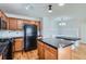 Kitchen with wood cabinets, granite countertops, and black appliances at 15800 E 121St Ave # 3J, Brighton, CO 80603