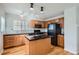 Kitchen with oak cabinets, granite island, and black appliances at 15800 E 121St Ave # 3J, Brighton, CO 80603