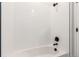 Modern bathroom bathtub and shower feature updated fixtures and white tiling with minimalist design at 5785 N Jericho Way, Aurora, CO 80019