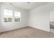 Bright bedroom featuring neutral carpet, white walls, and natural light from two windows at 5785 N Jericho Way, Aurora, CO 80019