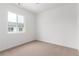 Bedroom featuring neutral carpet, white walls, and natural light from a window at 5785 N Jericho Way, Aurora, CO 80019