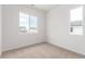 Cozy bedroom with neutral carpet, white walls, and natural light from two windows at 5785 N Jericho Way, Aurora, CO 80019