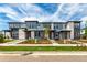 Charming townhome complex featuring modern architectural design, gray siding, stone accents, and manicured landscaping at 5785 N Jericho Way, Aurora, CO 80019