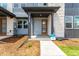 Inviting covered front entryway featuring a modern wood door, stone accents, and landscaped mulch beds at 5785 N Jericho Way, Aurora, CO 80019