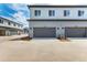Townhome garages featuring gray doors, gray siding and convenient access to parking areas at 5785 N Jericho Way, Aurora, CO 80019