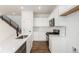 Modern kitchen featuring white cabinets, stainless steel appliances, quartz countertops, wood floor and black faucet at 5785 N Jericho Way, Aurora, CO 80019