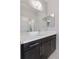 Clean bathroom showcases a sleek vanity with a white countertop and dark wood cabinets, enhanced by a large mirror at 11025 Watermark St, Parker, CO 80134