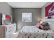 Cozy bedroom with a cheerful dinosaur patterned bedspread is lit by a bright window at 11025 Watermark St, Parker, CO 80134