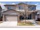Charming two-story home featuring a two-car garage, covered porch with stone accents, and well-manicured lawn at 11025 Watermark St, Parker, CO 80134
