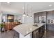 Open-concept kitchen with island, stainless steel appliances, and seamless flow to living room at 11025 Watermark St, Parker, CO 80134