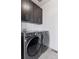 Efficient laundry room featuring modern washer and dryer units, along with ample storage space in the sleek overhead cabinets at 11025 Watermark St, Parker, CO 80134
