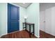 Entryway features wood flooring, a blue door, and a table with a lamp, creating a welcoming atmosphere at 26310 E 3Rd Pl, Aurora, CO 80018