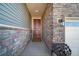 Covered entrance with a dark wood door, stone accents, and a stylish exterior light fixture at 26310 E 3Rd Pl, Aurora, CO 80018