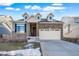 Charming two-story home with stone accents, an attached two-car garage, and a well-manicured front yard at 26310 E 3Rd Pl, Aurora, CO 80018