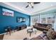 Bright living room with blue accent wall, comfortable leather seating, and a flat-screen TV for relaxation at 26310 E 3Rd Pl, Aurora, CO 80018