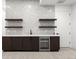 Stylish wet bar features a wine cooler, dark cabinets, open shelving and decorative tile backsplash at 1823 W 35Th Ave, Denver, CO 80211