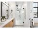 Stylish bathroom features a quartz countertop vanity, black fixtures, and a glass-enclosed shower with white tile at 1823 W 35Th Ave, Denver, CO 80211