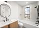 Modern bathroom features vanity, black fixtures, sleek tiling, a soaking tub, and window for natural light at 1823 W 35Th Ave, Denver, CO 80211