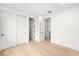 Bright bedroom with white walls, light hardwood floors, and multiple closets and doorways at 1823 W 35Th Ave, Denver, CO 80211