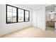 Minimalist bedroom features large window for natural light, white walls, and ensuite bathroom with modern fixtures at 1823 W 35Th Ave, Denver, CO 80211