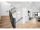 Bright hallway with wood stairs and black railing and views into the kitchen and living room at 1823 W 35Th Ave, Denver, CO 80211