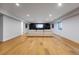 Spacious basement with bright white walls, a long sofa, and a large-screen TV at 1518 S Columbine St, Denver, CO 80210