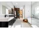 Stylish bathroom featuring double sinks, wood accents, a soaking tub, and contemporary fixtures at 1518 S Columbine St, Denver, CO 80210