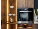 Close up of a modern stainless steel oven next to custom cabinets with display shelving at 1518 S Columbine St, Denver, CO 80210