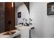 A modern powder room featuring a unique mirror, fixtures, and floating vanity at 1518 S Columbine St, Denver, CO 80210