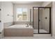 Bright bathroom with soaking tub, and separate glass shower, next to a window at 6514 Agave Ave, Castle Rock, CO 80108