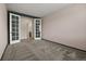 Empty bedroom features french doors leading to bath and closet; gray walls and carpet at 6514 Agave Ave, Castle Rock, CO 80108