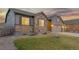 Well-maintained exterior view of home, showing a stone facade, gray siding, and manicured front lawn at 6514 Agave Ave, Castle Rock, CO 80108