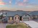 Aerial view showcasing a home's stone accents, well-manicured lawn, and a three-car garage at 6514 Agave Ave, Castle Rock, CO 80108