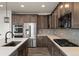 Spacious kitchen with stainless steel appliances, dark cabinets, and an island with quartz countertop at 6514 Agave Ave, Castle Rock, CO 80108