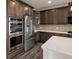 Modern kitchen with stainless steel appliances, dark wood cabinets, and quartz countertops at 6514 Agave Ave, Castle Rock, CO 80108