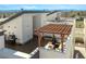 Relaxing rooftop deck featuring stylish pergola, seating area, and a grill setup at 1336 Sheridan Blvd # 108, Denver, CO 80214