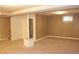Finished basement space with carpet, paneled walls, drop ceiling, and a doorway to the bathroom at 10759 Ogden St, Northglenn, CO 80233