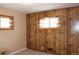 This bedroom has wood paneling and two windows with patterned curtains for natural light at 10759 Ogden St, Northglenn, CO 80233