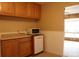 Clean and functional kitchen with light wood cabinets, white appliances, and tiled floors at 10759 Ogden St, Northglenn, CO 80233